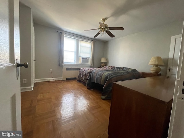 bedroom featuring ceiling fan, parquet flooring, and radiator heating unit