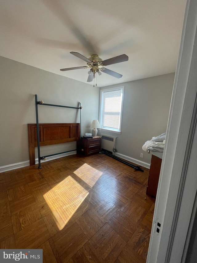 unfurnished bedroom featuring baseboard heating, dark parquet floors, and ceiling fan