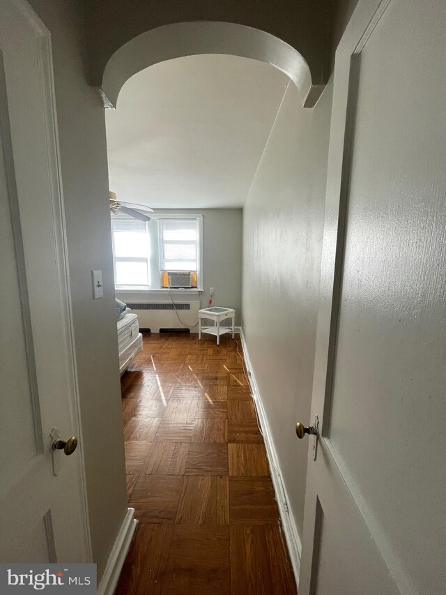 hallway featuring dark parquet floors, cooling unit, and radiator heating unit