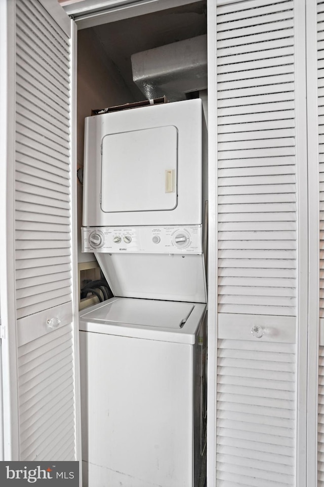 laundry room with stacked washing maching and dryer