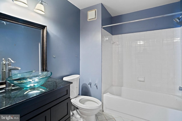 full bathroom with tile patterned flooring, tiled shower / bath, vanity, and toilet