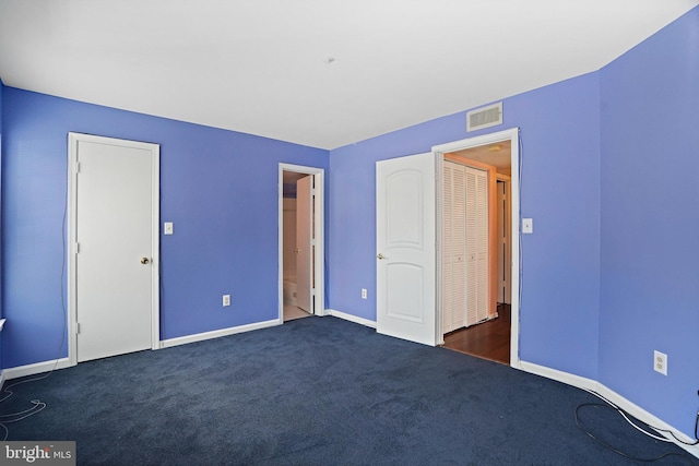 unfurnished bedroom with dark colored carpet