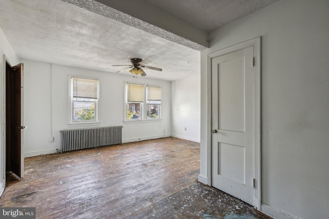 unfurnished room featuring ceiling fan, a textured ceiling, wood-type flooring, and radiator