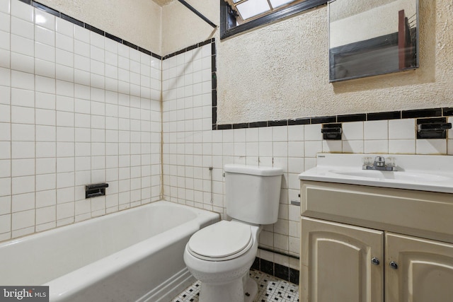 full bathroom with tile walls, vanity, toilet, and tile patterned flooring