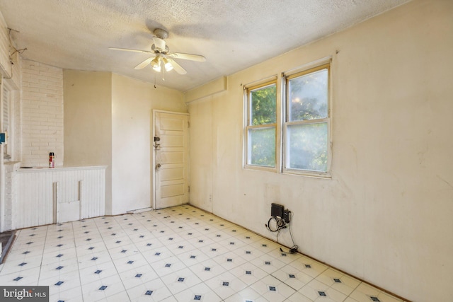 spare room with a textured ceiling and ceiling fan