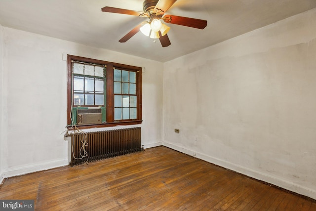 spare room with cooling unit, radiator heating unit, dark hardwood / wood-style floors, and ceiling fan