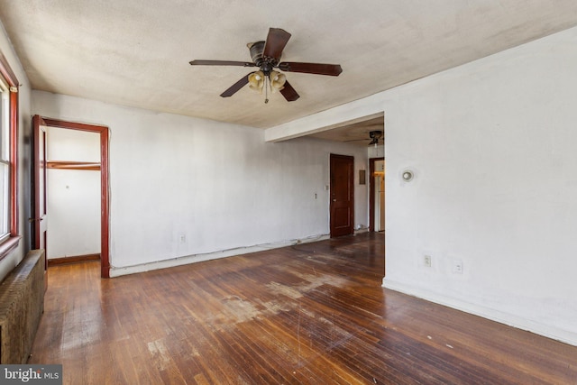 unfurnished room featuring ceiling fan, a textured ceiling, dark hardwood / wood-style flooring, and radiator heating unit