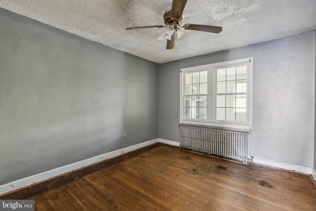 spare room with dark wood-type flooring, radiator heating unit, a textured ceiling, and ceiling fan