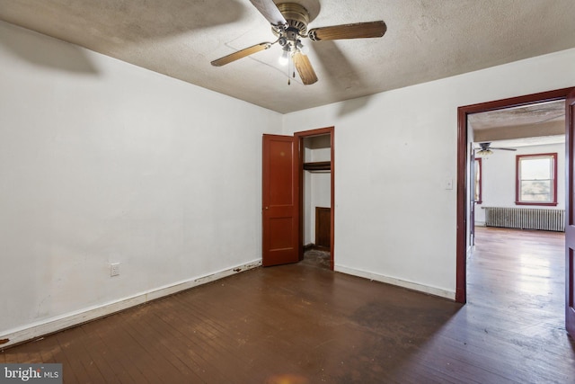 unfurnished bedroom with a textured ceiling, radiator heating unit, dark hardwood / wood-style floors, and ceiling fan