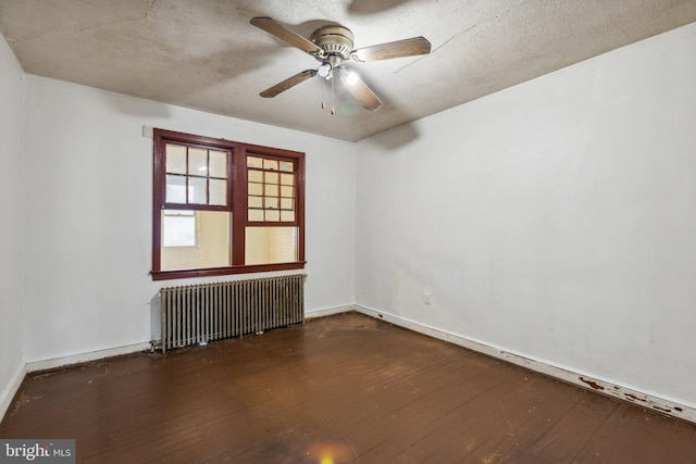 empty room featuring radiator heating unit, ceiling fan, a textured ceiling, and dark hardwood / wood-style flooring