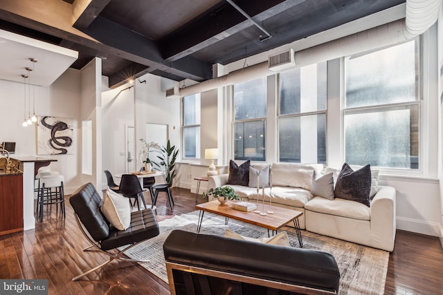 living room featuring beamed ceiling and dark hardwood / wood-style floors