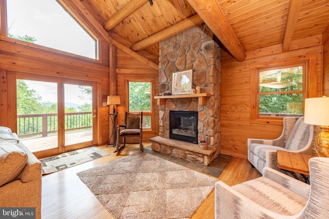 living room with light wood-type flooring, wood ceiling, and plenty of natural light