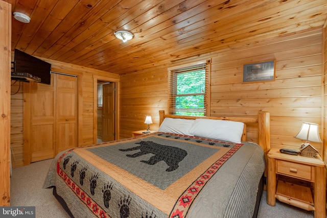 carpeted bedroom with a closet, wooden walls, and wooden ceiling