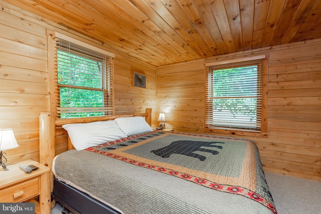 bedroom featuring wood walls and multiple windows