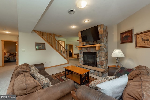 living room featuring a stone fireplace and carpet