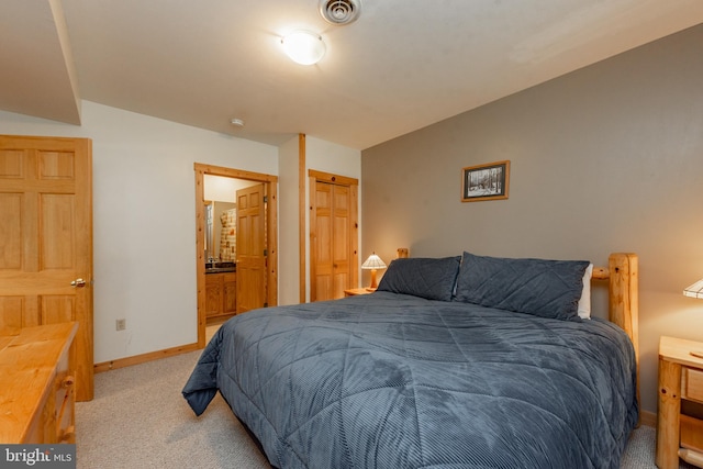 bedroom with ensuite bath, light carpet, and a closet