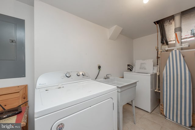 laundry room with electric panel, light tile patterned floors, and washing machine and clothes dryer