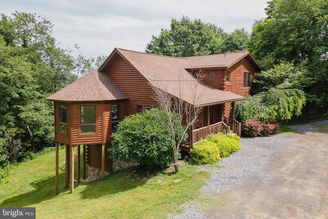 view of home's exterior with covered porch and a lawn