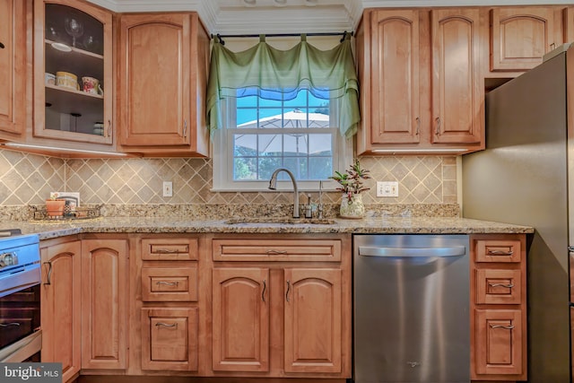 kitchen with light stone countertops, decorative backsplash, sink, and stainless steel appliances