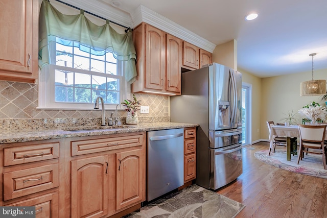 kitchen with sink, tasteful backsplash, decorative light fixtures, light hardwood / wood-style flooring, and stainless steel appliances