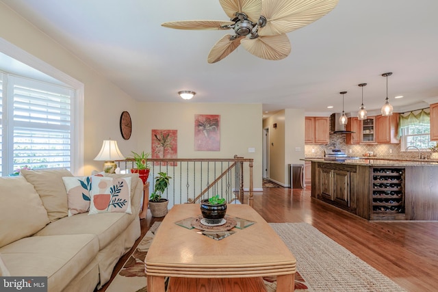 living room with wood-type flooring, sink, and ceiling fan