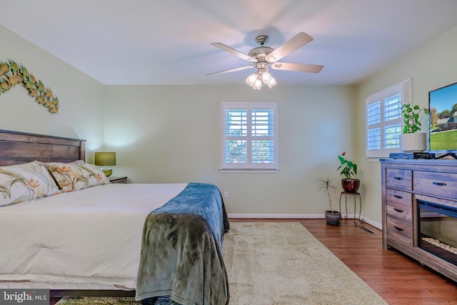 bedroom featuring hardwood / wood-style flooring, multiple windows, and ceiling fan