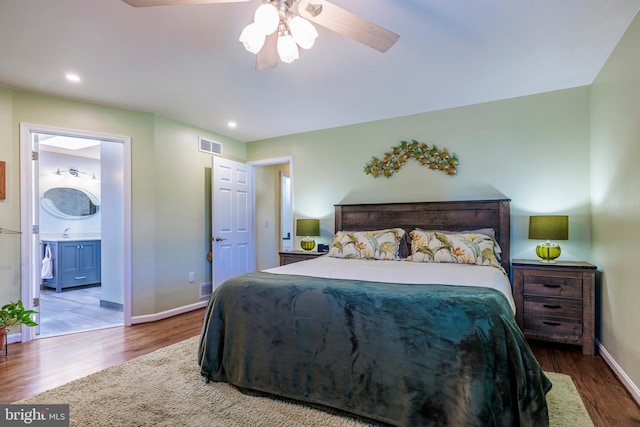 bedroom featuring ceiling fan, hardwood / wood-style flooring, sink, and ensuite bathroom