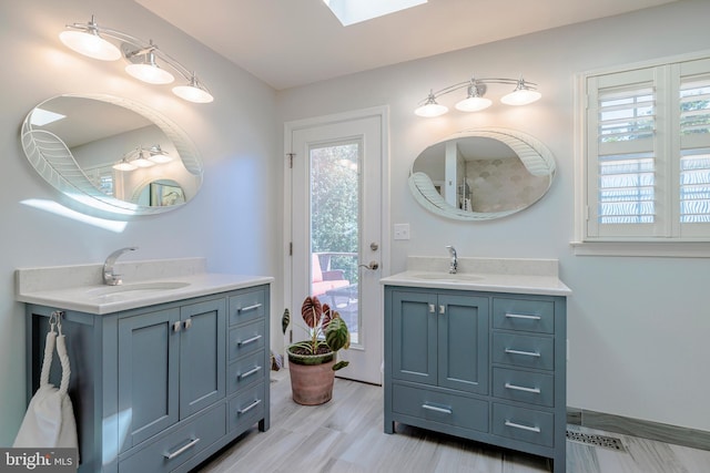 bathroom featuring a skylight, vanity, and hardwood / wood-style flooring