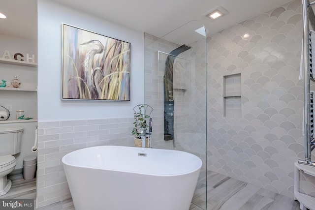 full bath featuring a freestanding tub, recessed lighting, walk in shower, toilet, and tile walls