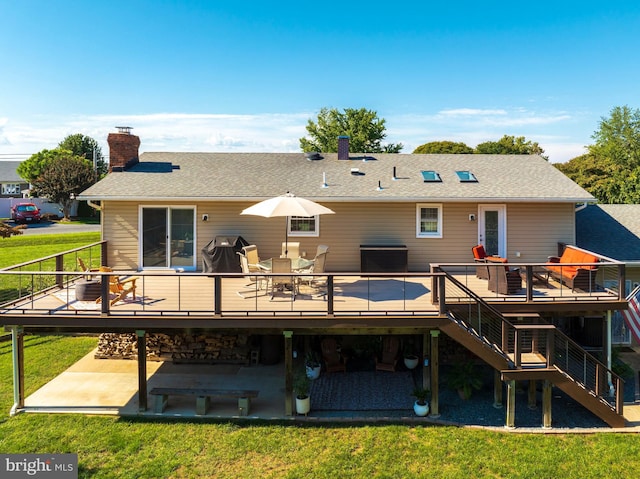 rear view of property featuring a yard and a deck