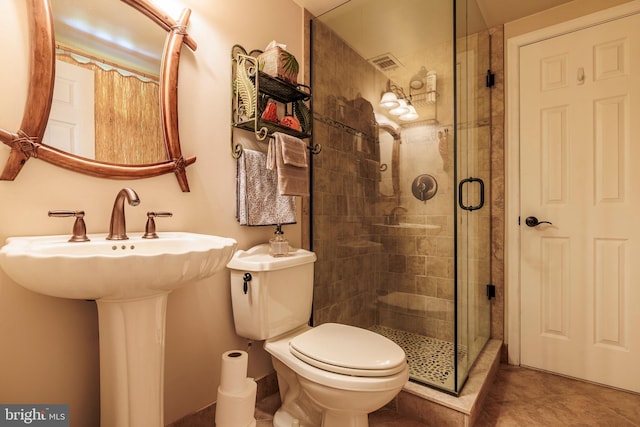 bathroom with walk in shower, sink, toilet, and tile patterned floors