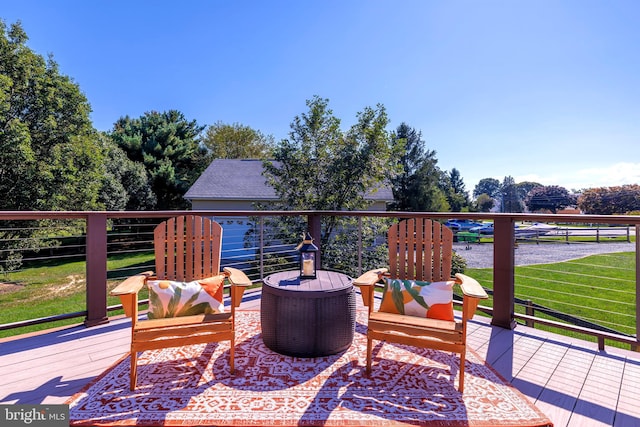 wooden deck featuring a garage and a yard