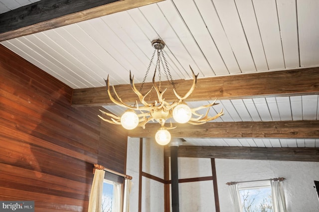 details featuring beam ceiling, wooden walls, wood ceiling, and a chandelier