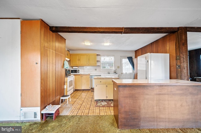 kitchen featuring a textured ceiling, white appliances, and wooden walls