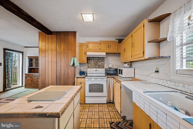 kitchen featuring tile counters, white appliances, beamed ceiling, and plenty of natural light