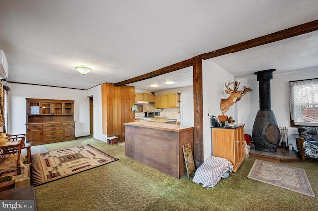 kitchen featuring a wood stove, beamed ceiling, white electric range oven, and dark colored carpet