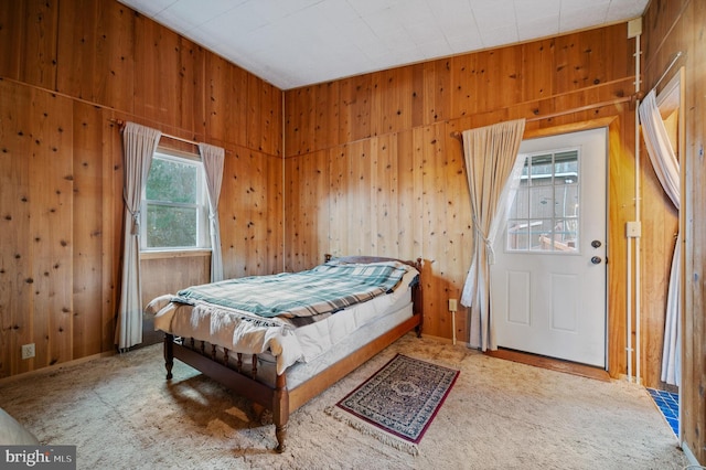 carpeted bedroom with wood walls