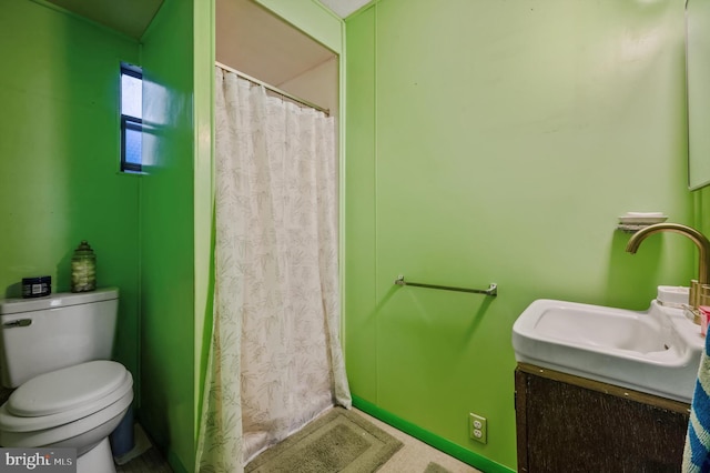 bathroom with walk in shower, sink, and toilet