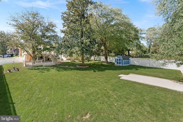 view of yard with a wooden deck and a shed