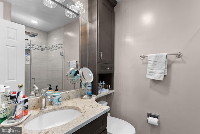 bathroom with toilet, vanity, and tiled shower