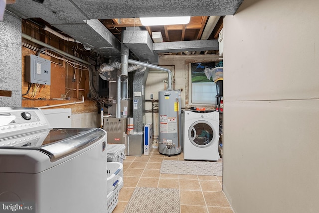 laundry area with gas water heater, heating unit, light tile patterned flooring, and washer / dryer