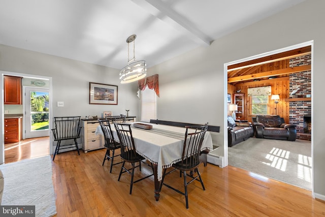 dining space with baseboard heating, beam ceiling, and light wood-type flooring