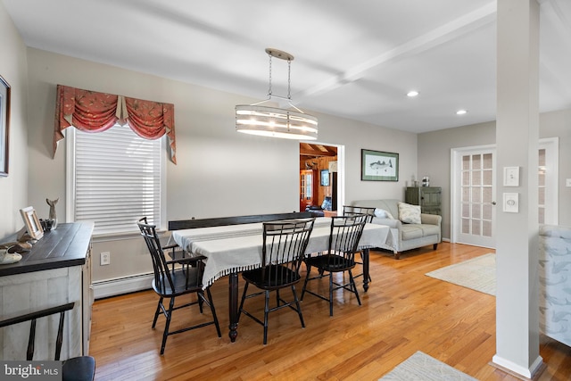 dining space featuring a baseboard heating unit and light wood-type flooring