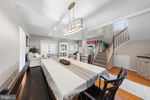 dining room with french doors, light hardwood / wood-style flooring, and a chandelier