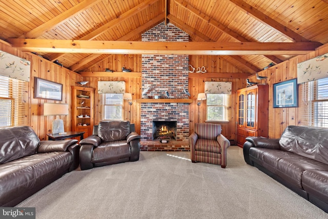 carpeted living room with vaulted ceiling with beams, wood ceiling, wooden walls, and a brick fireplace