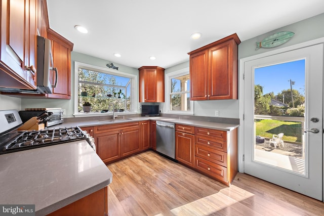 kitchen featuring sink, appliances with stainless steel finishes, and light wood-type flooring