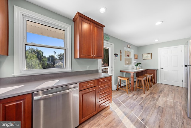 kitchen featuring light hardwood / wood-style floors, a baseboard heating unit, and stainless steel dishwasher