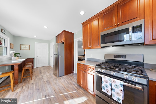 kitchen featuring appliances with stainless steel finishes and light hardwood / wood-style flooring