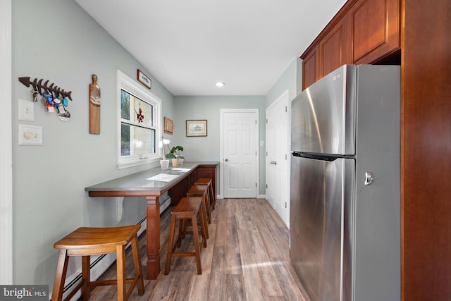 kitchen featuring hardwood / wood-style flooring and stainless steel fridge