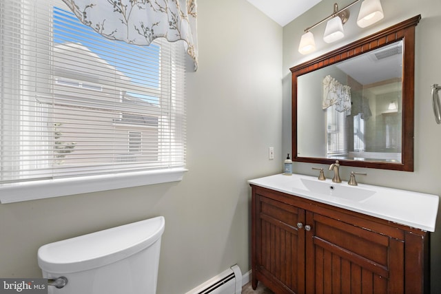 bathroom featuring a wealth of natural light, vanity, toilet, and baseboard heating